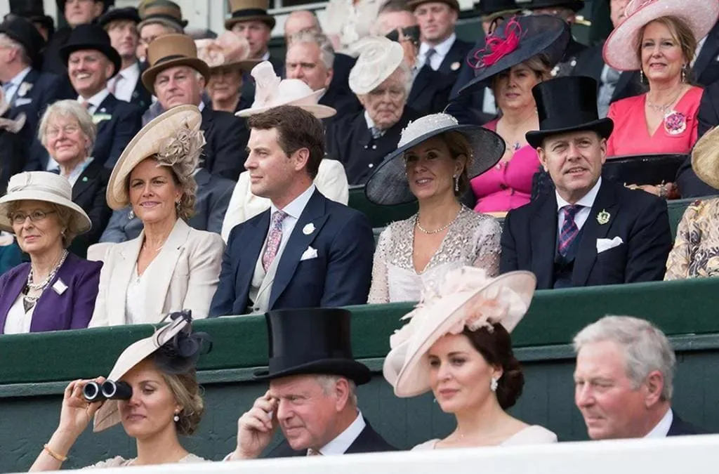 Público elegantemente vestido en Royal Ascot con sombreros tradicionales observando las carreras