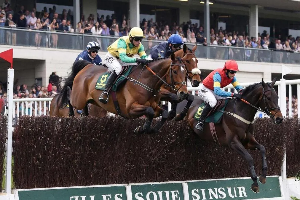 Caballos saltando la valla The Chair, el obstáculo más alto del Grand National